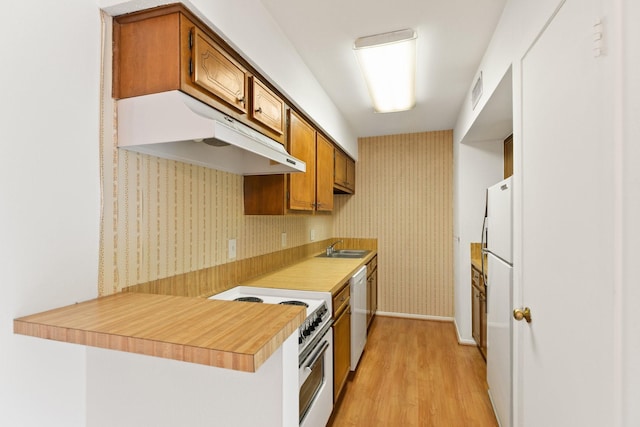 3131 Cummins St Unit 50, Houston, TX 77027 - kitchen with white appliances, under cabinet range hood, wallpapered walls, a sink, and light wood-type flooring