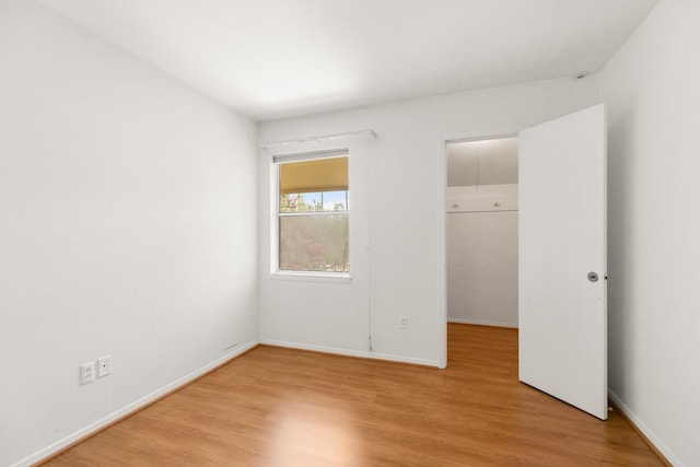 3131 Cummins St Unit 50, Houston, TX 77027 - unfurnished bedroom with light wood-type flooring, a spacious closet, and baseboards