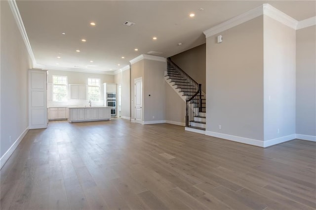 821 Dunleigh Meadows Ln, Houston, TX 77055 - unfurnished living room with ornamental molding, light wood-type flooring, stairway, and recessed lighting