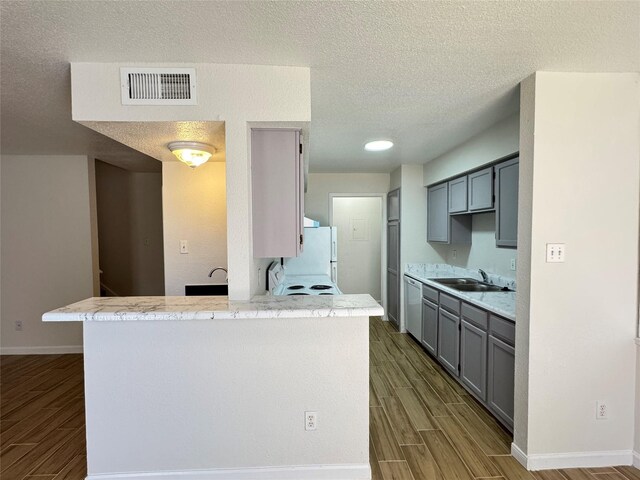 6500 Sands Point Dr Unit 114, Houston, TX 77074 - kitchen featuring dark wood-type flooring, freestanding refrigerator, gray cabinetry, light countertops, and a textured ceiling