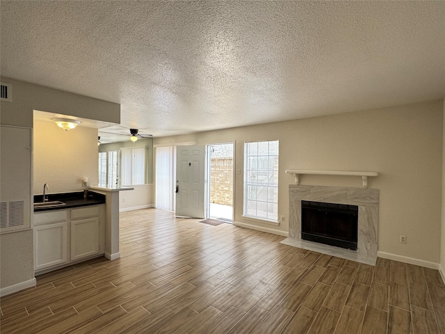 6500 Sands Point Dr Unit 114, Houston, TX 77074 - unfurnished living room featuring a sink, baseboards, wood finished floors, a ceiling fan, and a textured ceiling