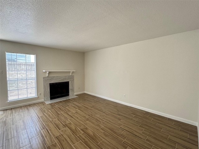 6500 Sands Point Dr Unit 114, Houston, TX 77074 - unfurnished living room with dark wood-type flooring, a premium fireplace, baseboards, and a textured ceiling