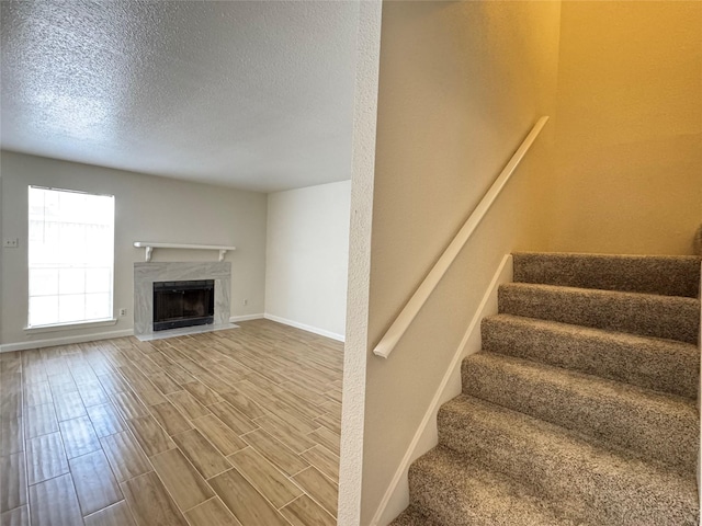 6500 Sands Point Dr Unit 114, Houston, TX 77074 - staircase with baseboards, a fireplace, wood finished floors, and a textured ceiling