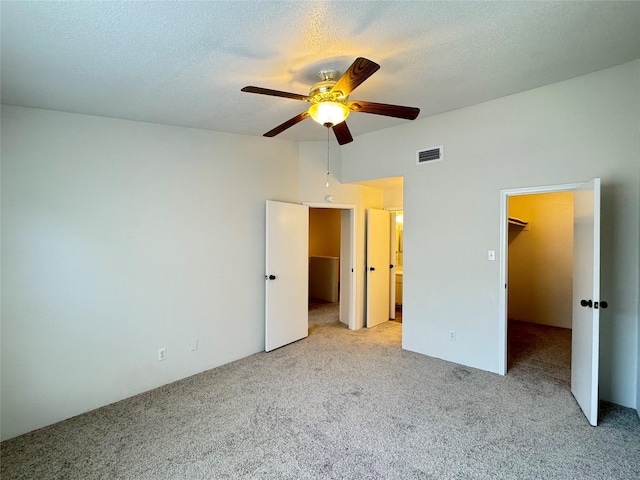 6500 Sands Point Dr Unit 114, Houston, TX 77074 - unfurnished bedroom featuring carpet floors, a walk in closet, a textured ceiling, ensuite bathroom, and ceiling fan