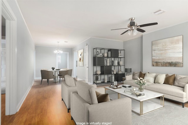 4514 Keystone St, Houston, TX 77021 - living room with a chandelier, a ceiling fan, wood finished floors, crown molding, and baseboards