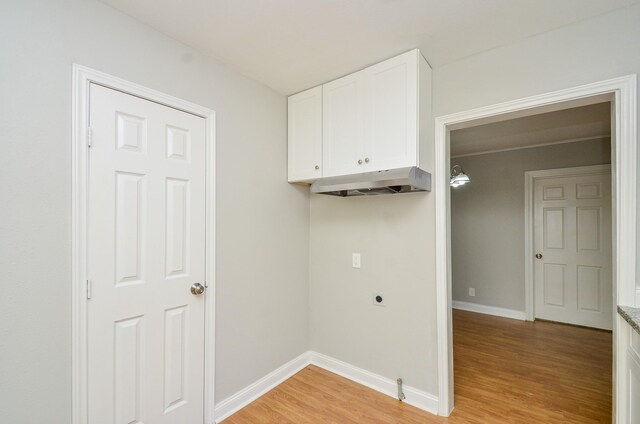 4514 Keystone St, Houston, TX 77021 - washroom featuring light wood-type flooring, baseboards, hookup for an electric dryer, and cabinet space