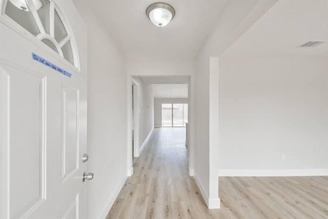 12523 Drifting Winds Dr, Houston, TX 77044 - corridor featuring light wood finished floors, baseboards, and a textured ceiling