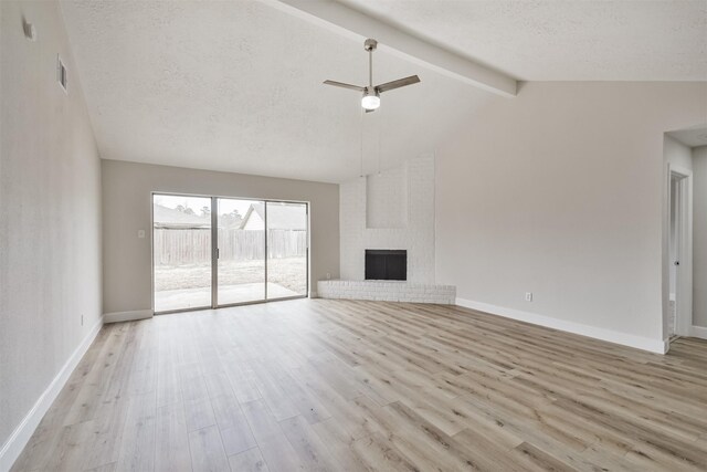 12523 Drifting Winds Dr, Houston, TX 77044 - unfurnished living room with wood finished floors, a textured ceiling, baseboards, a fireplace, and ceiling fan