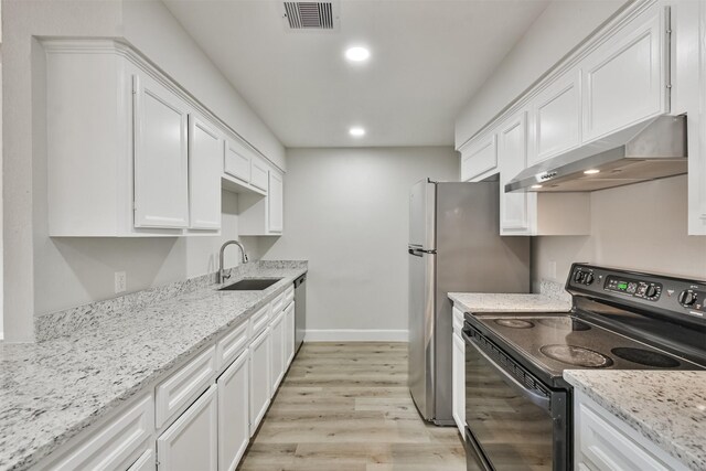 12523 Drifting Winds Dr, Houston, TX 77044 - kitchen with black electric range, a sink, under cabinet range hood, white cabinetry, and light wood-style flooring