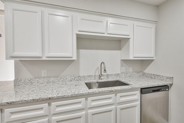 12523 Drifting Winds Dr, Houston, TX 77044 - kitchen with stainless steel dishwasher, a sink, white cabinetry, and light stone countertops