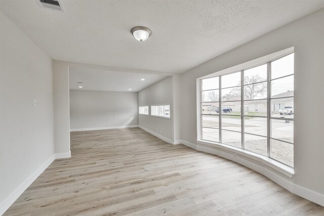 12523 Drifting Winds Dr, Houston, TX 77044 - unfurnished room with light wood finished floors, baseboards, a textured ceiling, and recessed lighting