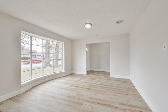 12523 Drifting Winds Dr, Houston, TX 77044 - empty room featuring light wood-type flooring, baseboards, and a textured ceiling