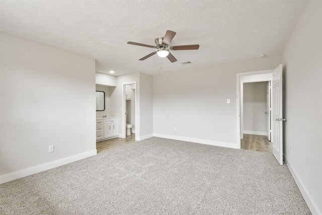 12523 Drifting Winds Dr, Houston, TX 77044 - empty room featuring light carpet, a ceiling fan, a textured ceiling, and baseboards