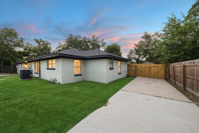 1301 Gulf St, Pasadena, TX 77502 - back of property at dusk with a gate, central air condition unit, concrete driveway, and brick siding