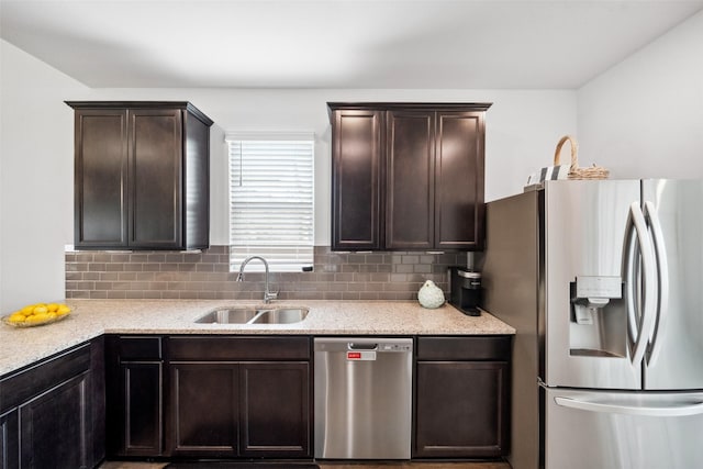 6006 Hazel Place Dr, Conroe, TX 77303 - kitchen with stainless steel appliances, a sink, dark brown cabinets, and backsplash