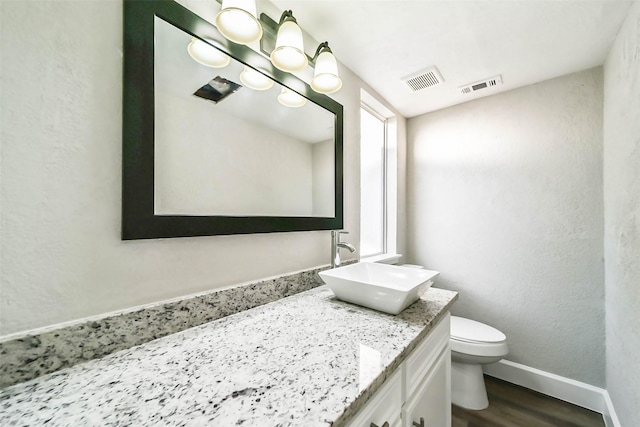 3522 Creekbriar Dr, Houston, TX 77068 - bathroom with vanity, baseboards, toilet, wood finished floors, and a textured wall