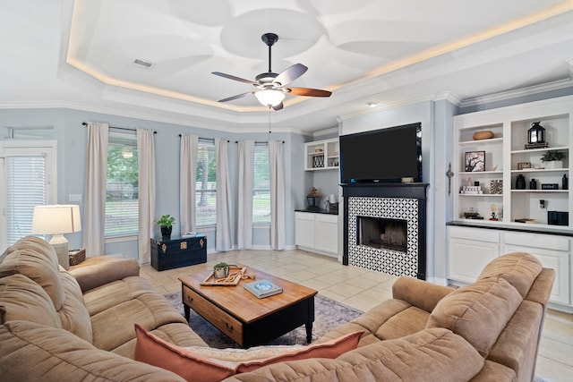 15 Rose Pine Ct, Magnolia, TX 77355 - living room featuring a raised ceiling, ceiling fan, crown molding, light tile patterned floors, and a fireplace