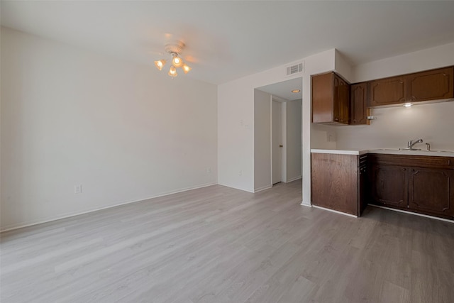 6103 Fondren Rd Unit 7, Houston, TX 77036 - kitchen with light countertops, a sink, light wood finished floors, and baseboards