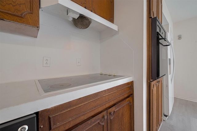 6103 Fondren Rd Unit 7, Houston, TX 77036 - kitchen with oven, electric stovetop, light countertops, and brown cabinetry