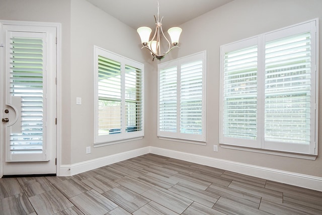 2334 Twin Rose Dr, Missouri City, TX 77459 - unfurnished dining area with a chandelier, baseboards, and wood finish floors