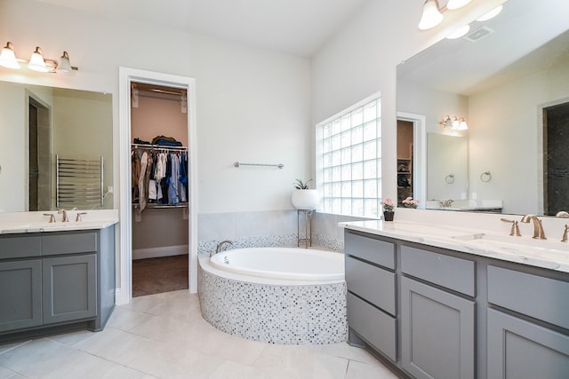 2334 Twin Rose Dr, Missouri City, TX 77459 - bathroom featuring radiator, two vanities, a garden tub, tile patterned floors, and a spacious closet