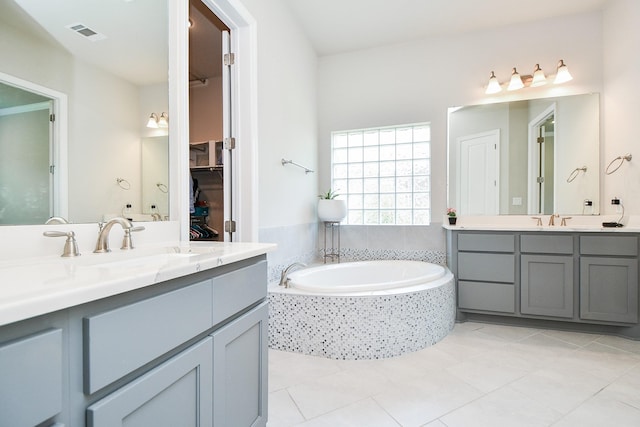 2334 Twin Rose Dr, Missouri City, TX 77459 - full bathroom featuring two vanities, a garden tub, tile patterned floors, and a spacious closet