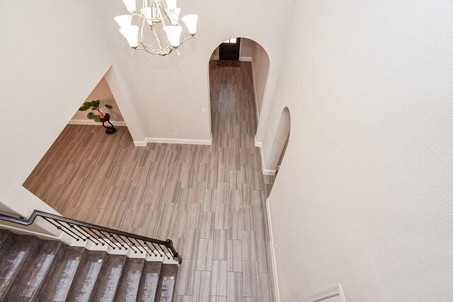 2334 Twin Rose Dr, Missouri City, TX 77459 - stairs featuring arched walkways, wood finished floors, baseboards, and a chandelier