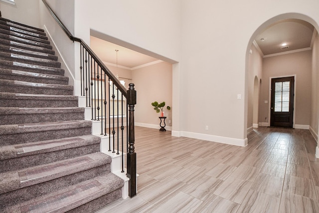 2334 Twin Rose Dr, Missouri City, TX 77459 - entryway with arched walkways, crown molding, stairs, baseboards, and a high ceiling