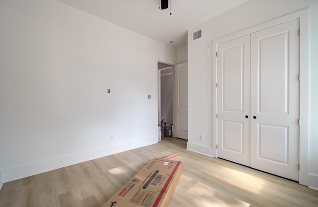 1802 Rollingwood Dr, Huntsville, TX 77340 - unfurnished bedroom featuring light wood-style flooring, baseboards, a closet, and ceiling fan
