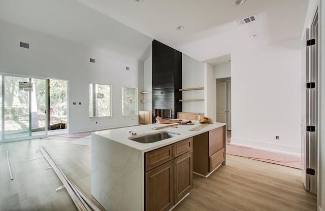 1802 Rollingwood Dr, Huntsville, TX 77340 - kitchen with open floor plan, high vaulted ceiling, light wood finished floors, light countertops, and a kitchen island with sink