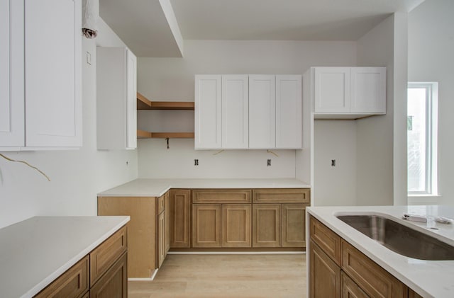 1802 Rollingwood Dr, Huntsville, TX 77340 - kitchen with brown cabinets, plenty of natural light, and light wood-style flooring