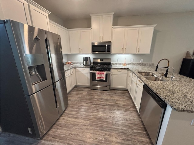 1404 Rd 5102, Cleveland, TX 77327 - kitchen with appliances with stainless steel finishes, a sink, a peninsula, light stone counters, and white cabinetry