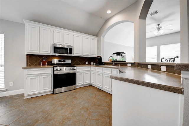 26622 Clear Mill Ln, Katy, TX 77494 - kitchen featuring stainless steel appliances, backsplash, vaulted ceiling, white cabinetry, and light tile patterned floors