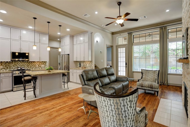 6710 Woodbend Park S, Houston, TX 77055 - living area with a ceiling fan, ornamental molding, light wood finished floors, recessed lighting, and arched walkways
