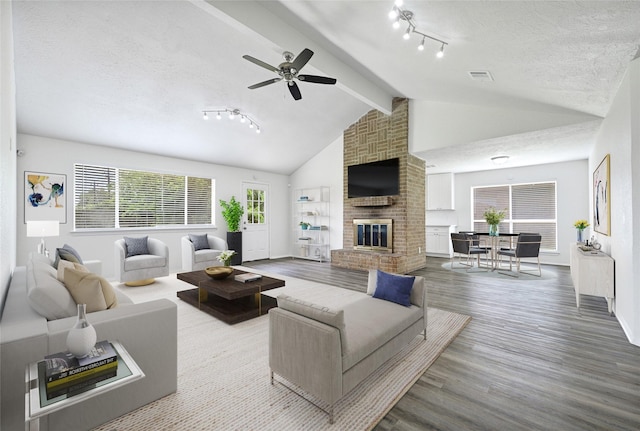 1323 Fieldstone, Missouri City, TX 77489 - living area featuring wood finished floors, track lighting, ceiling fan, a brick fireplace, and baseboards