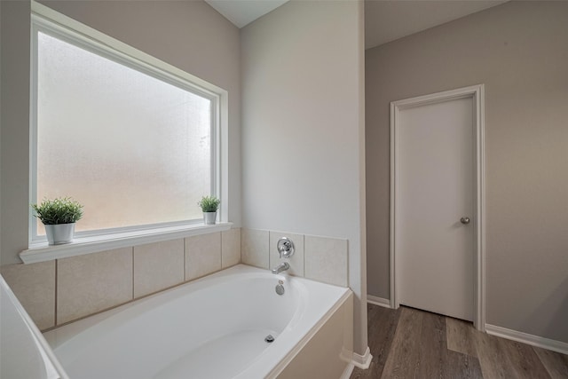 2810 Meadowbrook Ln, Rosenberg, TX 77471 - full bath featuring a bath, wood finished floors, and baseboards