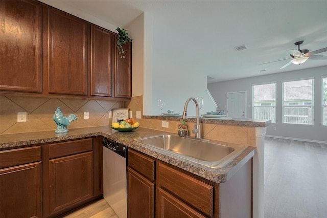 2810 Meadowbrook Ln, Rosenberg, TX 77471 - kitchen with stainless steel dishwasher, a peninsula, a sink, a ceiling fan, and tasteful backsplash