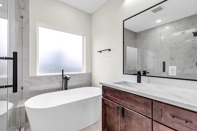 4908 Broom St, Houston, TX 77091 - full bathroom featuring vanity, a soaking tub, a marble finish shower, tile walls, and recessed lighting