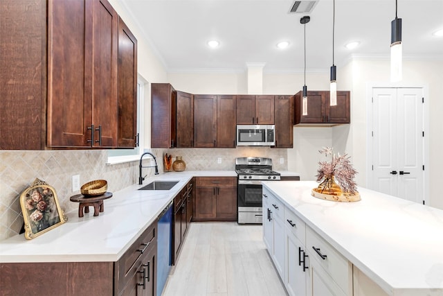 4908 Broom St, Houston, TX 77091 - kitchen with stainless steel appliances, a sink, crown molding, tasteful backsplash, and pendant lighting