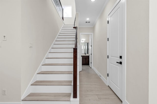 4908 Broom St, Houston, TX 77091 - stairway featuring crown molding, baseboards, recessed lighting, and wood finished floors