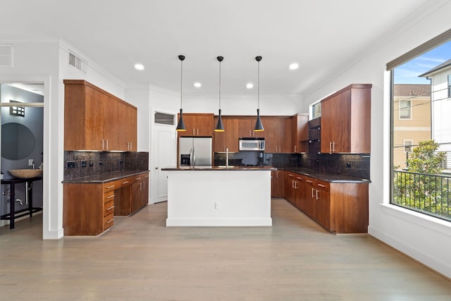 6217 Westcott St Unit B, Houston, TX 77007 - kitchen featuring stainless steel appliances, tasteful backsplash, pendant lighting, a center island, and light wood finished floors
