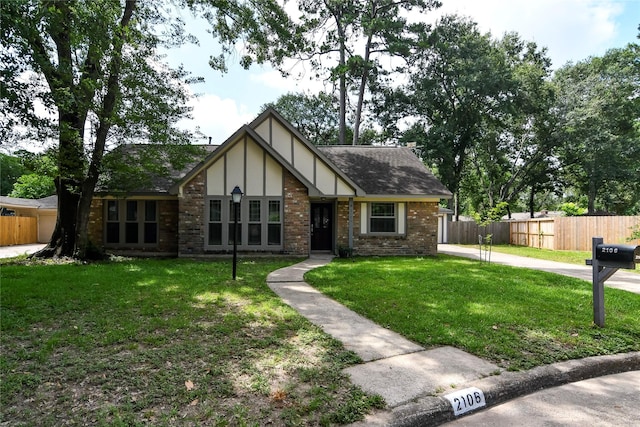 2106 Silver Falls Dr, Houston, TX 77339 - tudor house featuring roof with shingles, brick siding, and concrete driveway