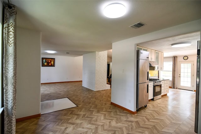 2106 Silver Falls Dr, Houston, TX 77339 - kitchen featuring gas range, baseboards, high end fridge, and white cabinetry