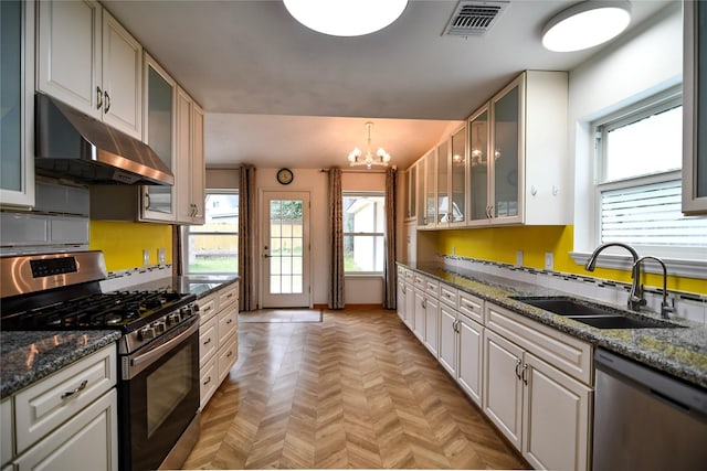 2106 Silver Falls Dr, Houston, TX 77339 - kitchen featuring appliances with stainless steel finishes, under cabinet range hood, a sink, a chandelier, and dark stone counters