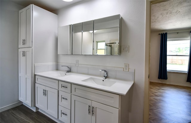 2106 Silver Falls Dr, Houston, TX 77339 - bathroom with double vanity, baseboards, wood finished floors, and a textured ceiling