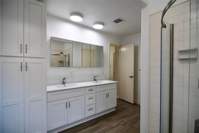 2106 Silver Falls Dr, Houston, TX 77339 - bathroom featuring double vanity, wood finished floors, and tiled shower