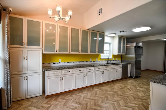2106 Silver Falls Dr, Houston, TX 77339 - kitchen featuring appliances with stainless steel finishes, a sink, a chandelier, white cabinetry, and decorative light fixtures