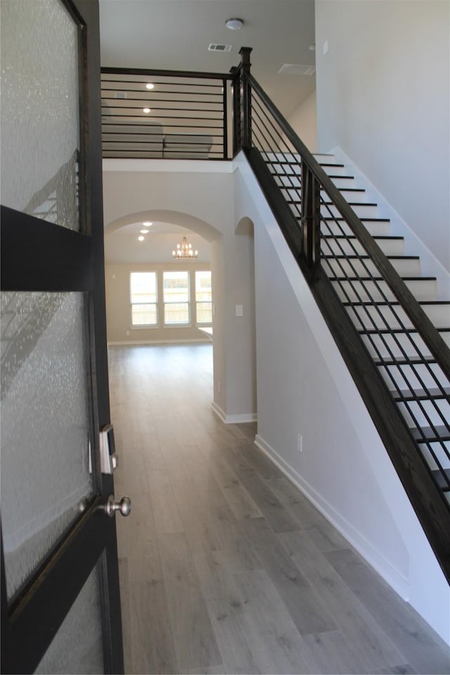 143 Nightshade St, Richmond, TX 77406 - stairway featuring arched walkways, wood finished floors, a chandelier, baseboards, and recessed lighting