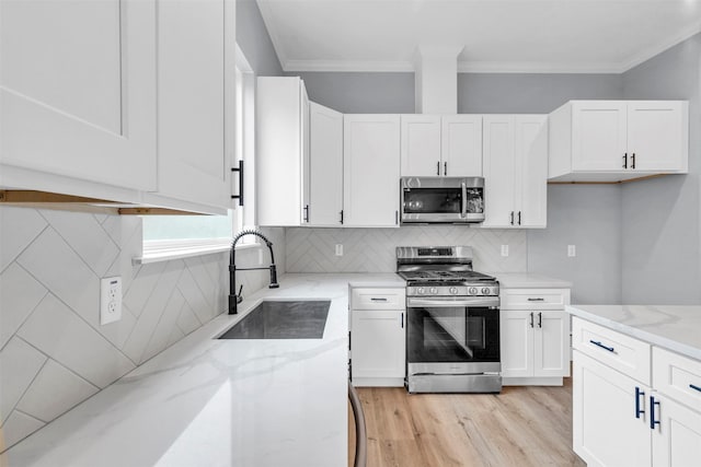 5029 Creekmont Dr, Houston, TX 77091 - kitchen with stainless steel appliances, a sink, light stone countertops, white cabinets, and light wood-type flooring