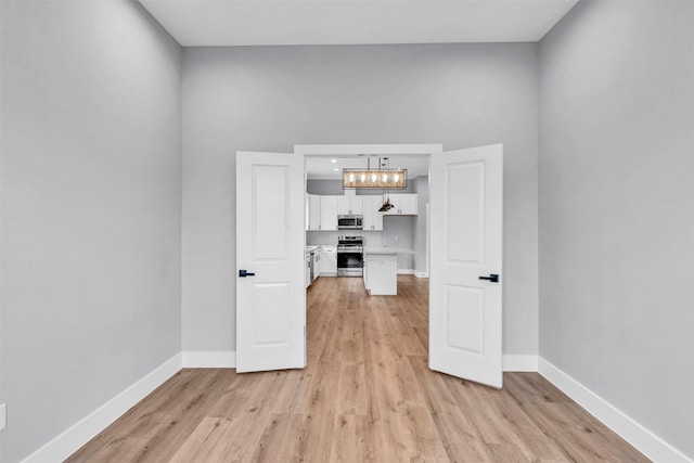 5029 Creekmont Dr, Houston, TX 77091 - spare room featuring light wood-style floors, baseboards, and a chandelier